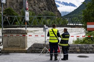 Deux pompiers surveillent le débit du Rhône le samedi 22 juin 2024 entre Sierre et Chippis